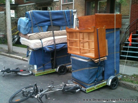 two bicycle trailers loaded with furniture