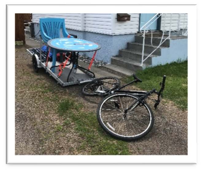 bike parked with trailer loaded with outdoor lawn furniture