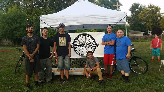 photo of Raúl and youth apprentices posing in front of their trailer