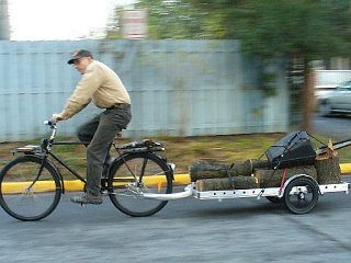 64A bicycle trailer loaded with logs and a chainsaw